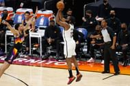 James Harden #13 of the Brooklyn Nets attempts a three-point shot over Abdel Nader #11 of the Phoenix Suns.